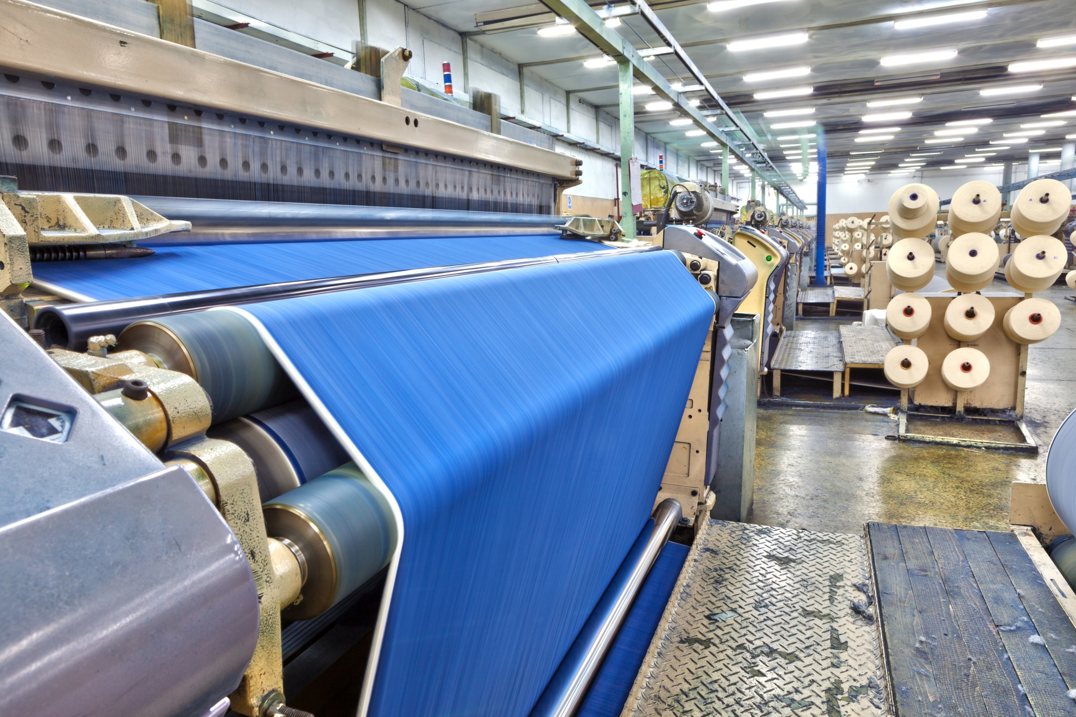 Weaving hemp fabric on air jet looms in a big textile weaving manufacturing plant.