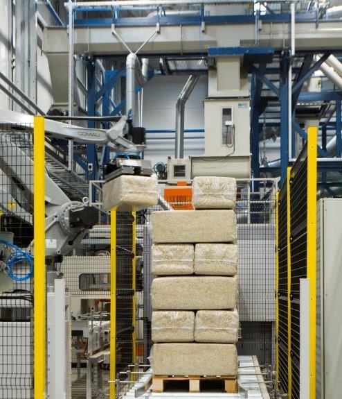 Machinery in an industrial hemp manufacturing facility stacking hemp building materials.